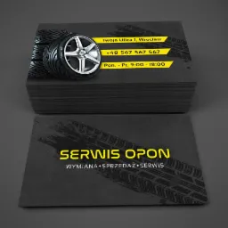 Stos wizytówek serwisu opon z grafiką opony, adresem, numerem telefonu i godzinami otwarcia, czarno-żółta kolorystyka.