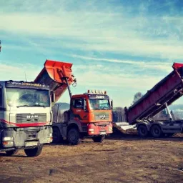 Cztery ciężarówki MAN z podniesionymi skrzyniami ładunkowymi na placu budowy, widoczne góry w tle pod błękitnym niebem z chmurami.
