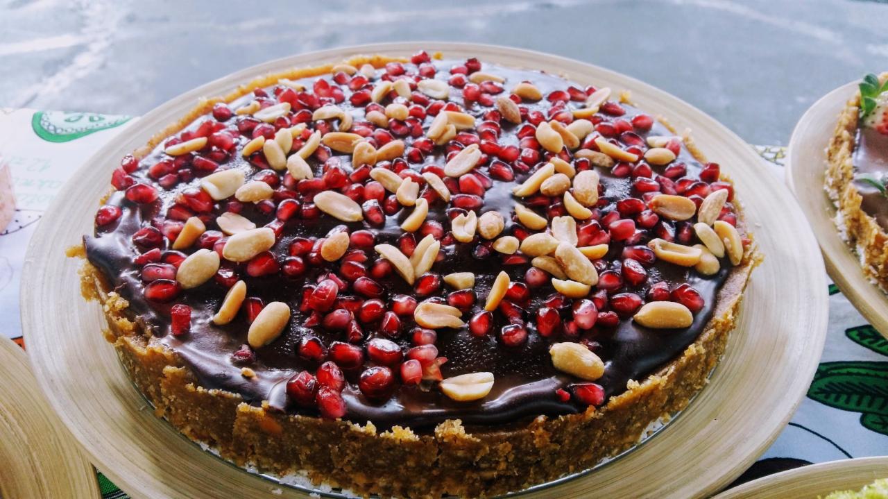 Tortilla z czekoladą, granatem i orzeszkami ziemnymi na drewnianej tacy, widok z góry.