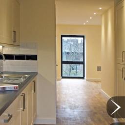 Propainting Sp z.o.o - Jasna kuchnia z widokiem na pokój z parkietem i oknem na zewnątrz