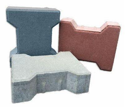 Trzy betonowe kostki brukowe o różnych kształtach i kolorach: szara, czerwona i niebieska, ułożone jedna na drugiej na białym tle.