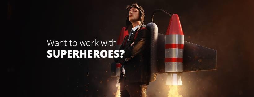 Mężczyzna w garniturze i goglach, z rakietowym plecakiem, prezentowany jako metafora 'superbohatera' w kontekście pracy, na ciemnym tle z tekstem 'Want to work with SUPERHEROES?'