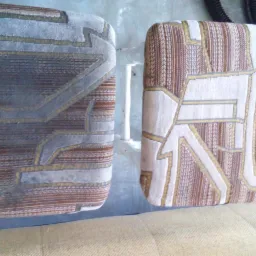 Dwa tapicerowane siedziska krzeseł przed i po czyszczeniu, widoczna różnica w kolorze i świeżości tkaniny, wzór geometryczny.