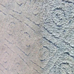 Zbliżenie na fragment dywanu z wyraźnym podziałem na część wyczyszczoną (jaśniejszą) i nie wyczyszczoną (ciemniejszą) z widocznym wzorem geometrycznym.