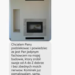 Minimalistyczny wkład kominkowy z obudową z jasnego kamienia, widoczny na zdjęciu z komunikatora.