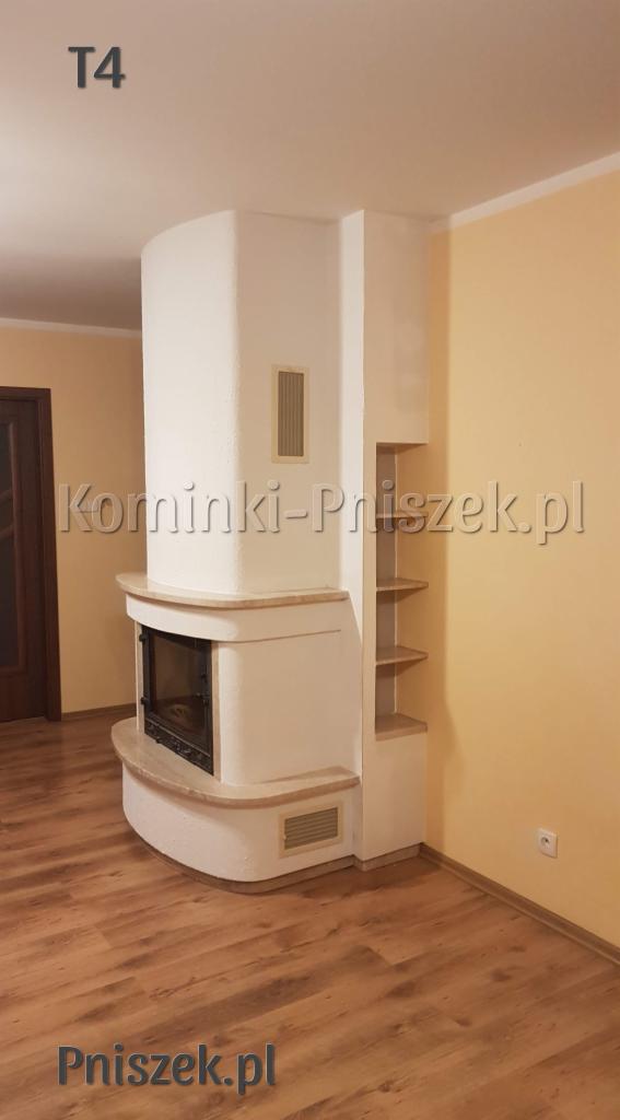 Biały, narożny piec z półkami, wykończony beżowym kamieniem, w jasnym wnętrzu z drewnianą podłogą.