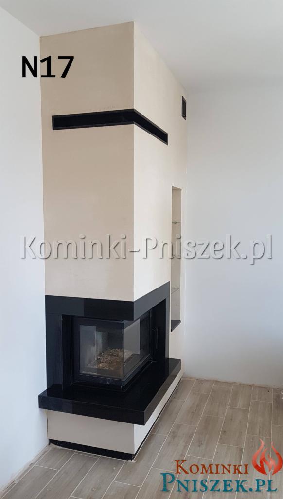 Nowoczesny narożny wkład kominkowy z czarnymi elementami wykończeniowymi, obudowany jasnym, gładkim tynkiem, widoczny z boku z elementami podświetlenia.