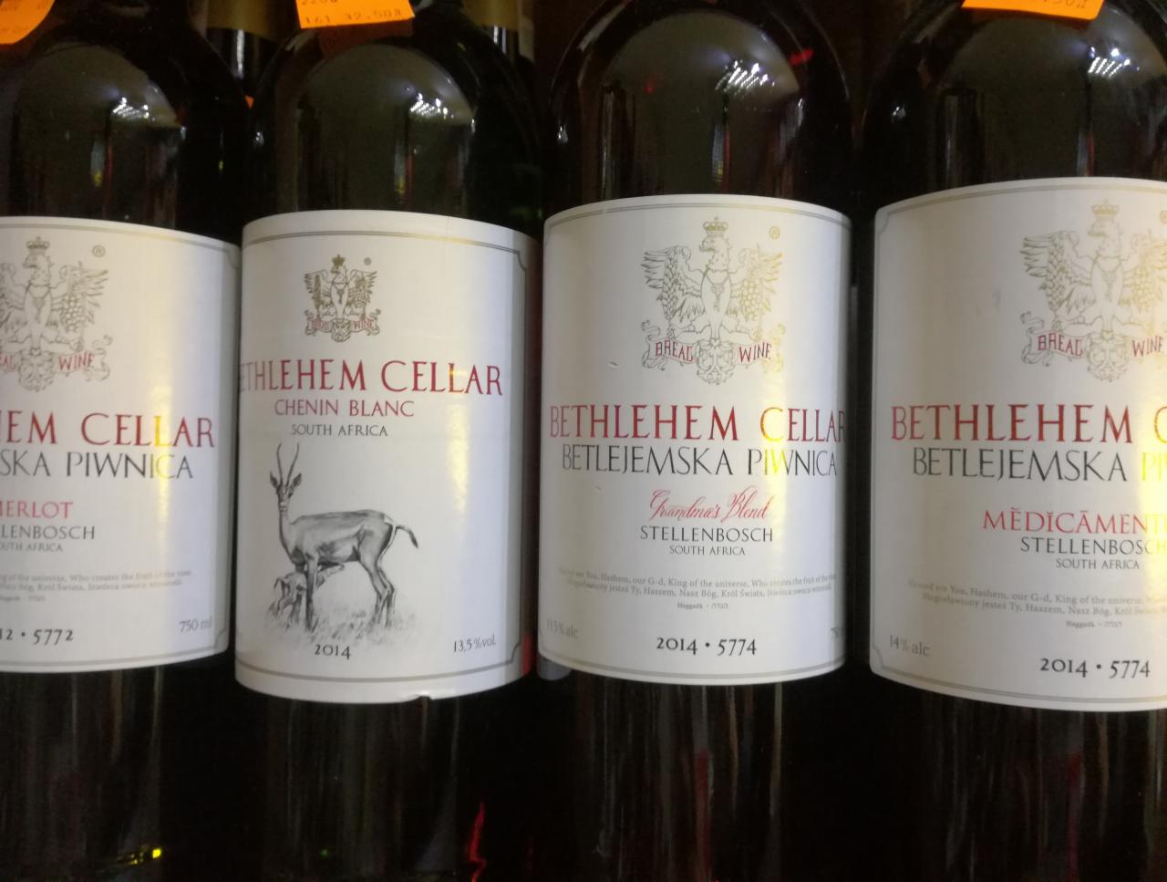 Butelki wina z etykietami Bethlehem Cellar, w tym Chenin Blanc z rysunkiem antylopy, ustawione w rzędzie, widoczne roczniki 2014 i logo Bread & Wine.