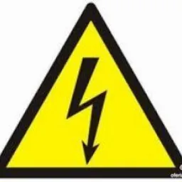 Żółty trójkąt ostrzegawczy z czarną obwódką i symbolem błyskawicy skierowanej w dół, oznaczający zagrożenie porażeniem prądem.