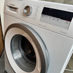 REPER24 SPÓŁKA Z OGRANICZONĄ ODPOWIEDZIALNOŚCIĄ - Biała pralka Bosch z panelem sterowania VarioPerfect i drzwiami z srebrną obwódką. Widoczny model EcoSilence Drive SilentLine.