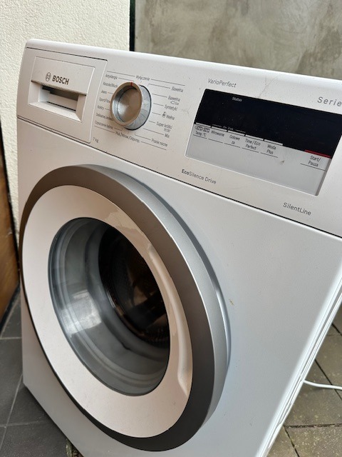 Biała pralka Bosch z panelem sterowania VarioPerfect i drzwiami z srebrną obwódką. Widoczny model EcoSilence Drive SilentLine.