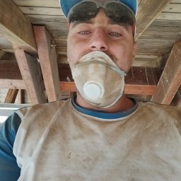 LUX&ART WNĘTRZA ŁUKASZ WĘGLOWSKI - Pracownik w masce i okularach ochronnych, ubrudzony farbą, podczas prac wykończeniowych w Lędyczku. Widoczna konstrukcja drewniana sufitu.