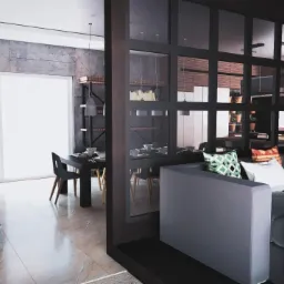 Nowoczesne wnętrze: szara sofa z dekoracyjnymi poduszkami i turkusowym pledem, oddzielona czarną, przeszkloną ścianką od jadalni z ciemnym stołem i krzesłami, betonowa ściana i schody z metalowymi...