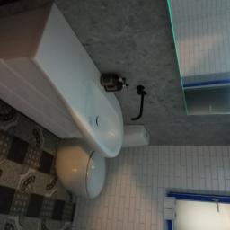 Abc Rusztowania Dawid Saganowski - Nowoczesna łazienka z wiszącą umywalką nablatową, toaletą i podświetlanym lustrem LED, wykończona szarą płytką imitującą beton na ścianach i podłodze z wzorzystymi kaflami.