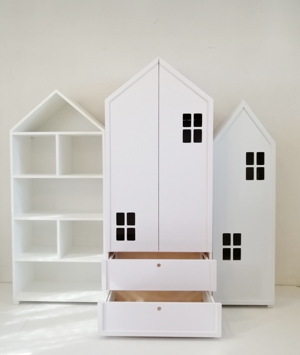 Białe meble dziecięce w kształcie domków: szafa dwudrzwiowa z szufladami i regał z półkami, całość w minimalistycznym stylu, z czarnymi 'oknami'.