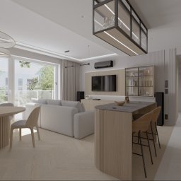 Modei Sztuka & Design - Nowoczesny salon z aneksem kuchennym i jadalnią. Jasne drewniane meble, ryflowane detale, biała sofa, okrągły stół z unikalną lampą wiszącą i wyspa z hokerami. Widok na zieleń.