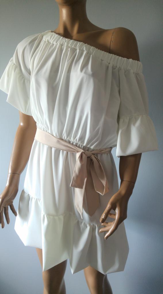 Biała, letnia sukienka mini z falbanami i beżowym paskiem, prezentowana na manekinie w Tomaszowie Mazowieckim.