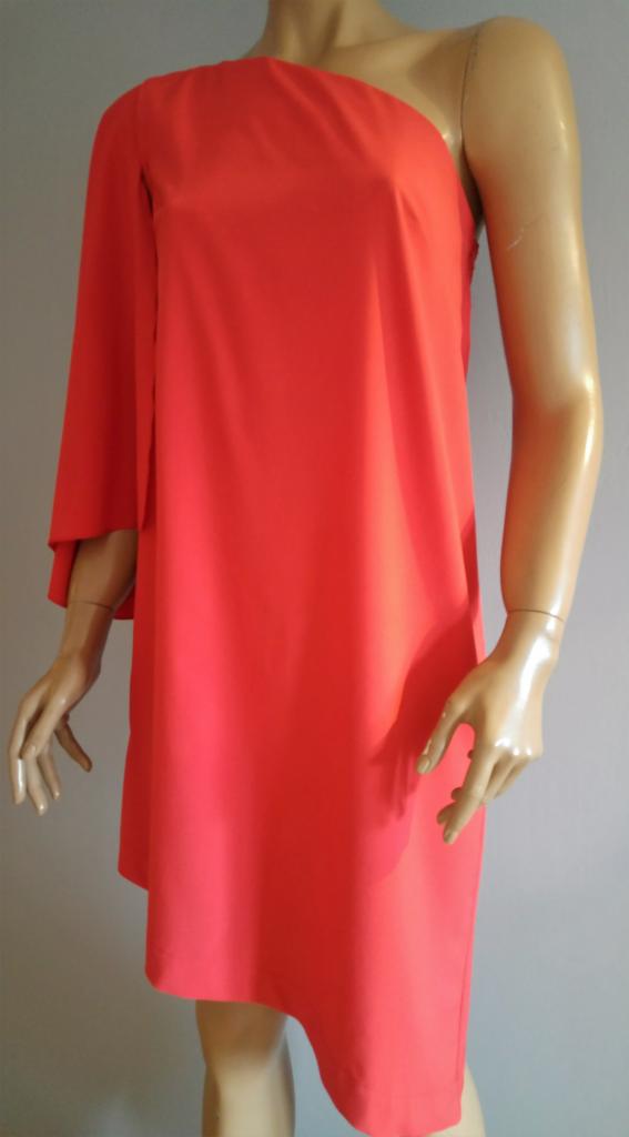 Pomarańczowa sukienka mini na jednym ramiączku, z asymetrycznym dołem, prezentowana na manekinie.