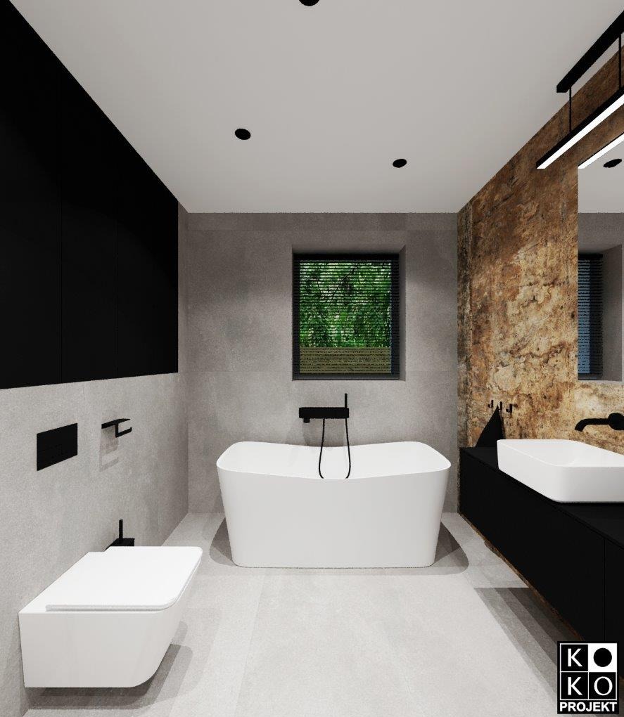 Nowoczesna łazienka z wolnostojącą wanną, czarnymi akcentami i oknem z widokiem na zieleń. Ściana z efektem kamienia dodaje charakteru. Minimalistyczny design.