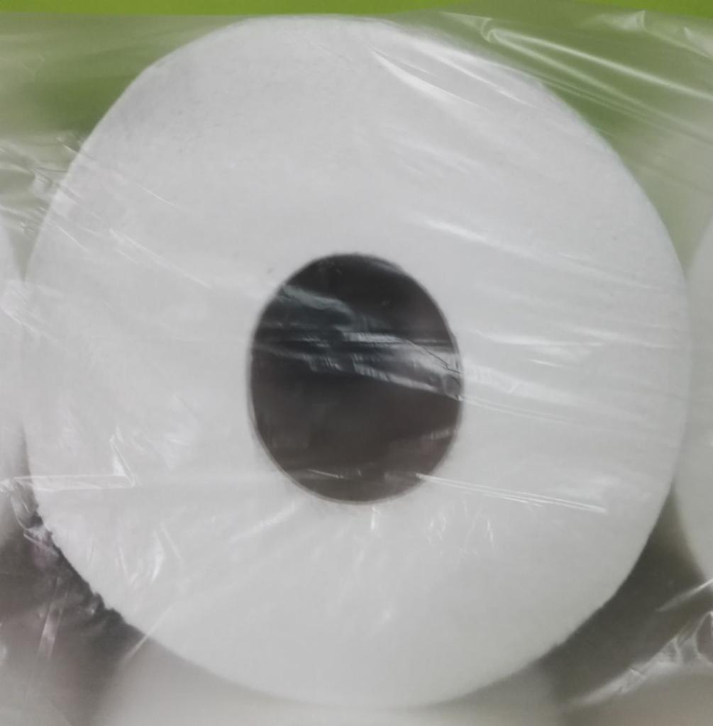 Rolka białego papieru toaletowego z widoczną, ciemną tekturą w środku, zapakowana w przezroczysty plastik.