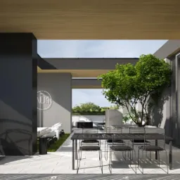 Nowoczesny taras z wiszącym fotelem, stołem jadalnym i pionową zieloną ścianą z paproci, widok na zewnątrz z meblami ogrodowymi.