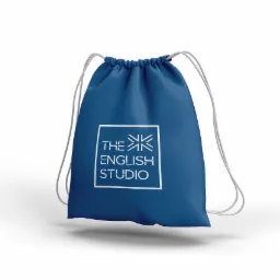 Niebieski worek ze sznurkiem, z białym nadrukiem logo 'The English Studio' w kwadratowej ramce, leżący na białym tle.