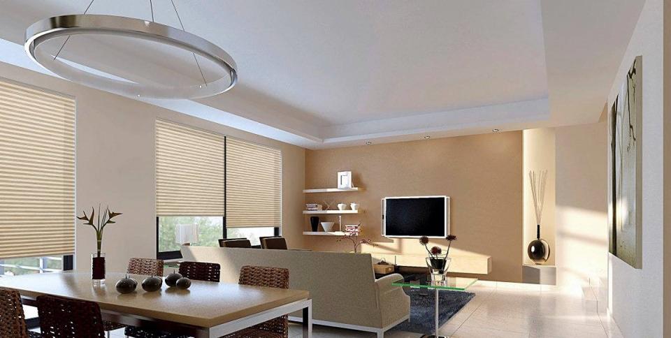 Beżowe plisy okienne w nowoczesnym salonie z okrągłą lampą sufitową i minimalistycznym wystrojem.