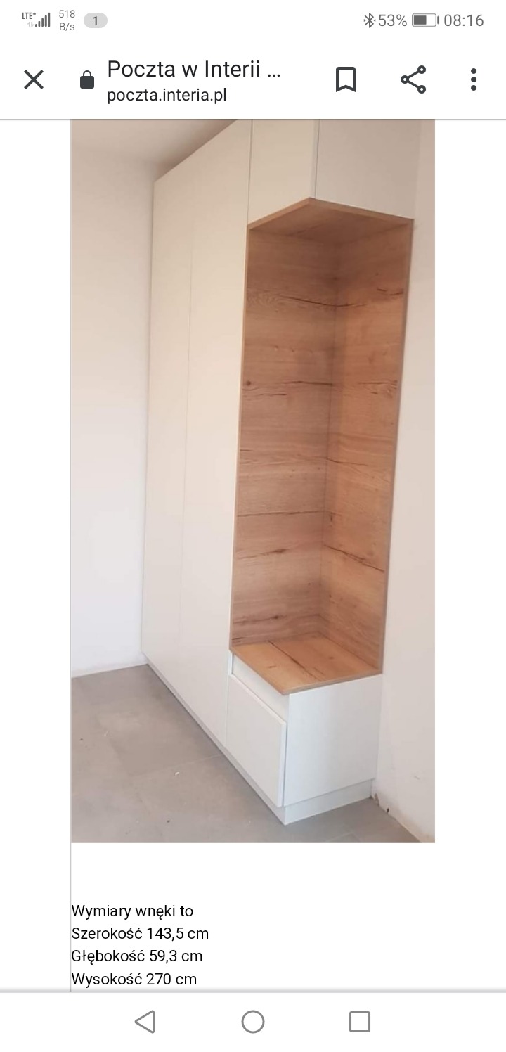 Biała szafa wnękowa z otwartą półką wykończoną drewnem, widoczny fragment szarej podłogi i biała ściana.