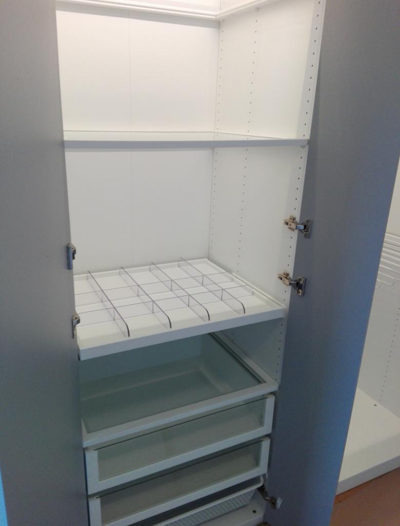 Wnętrze szafy na wymiar z szufladami z przezroczystym frontem, półką z przegródkami i regulowanymi półkami bocznymi.