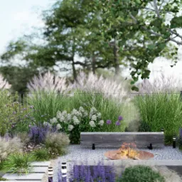 Ogród z paleniskiem otoczonym kamieniami, drewnianymi ławkami i ozdobnymi trawami oraz kwiatami, z miejscem na składowanie drewna w tle.