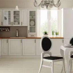 Jasna kuchnia z drewnianym blatem, białymi frontami szafek w stylu klasycznym, okrągłymi krzesłami i zdobnym żyrandolem nad stołem.