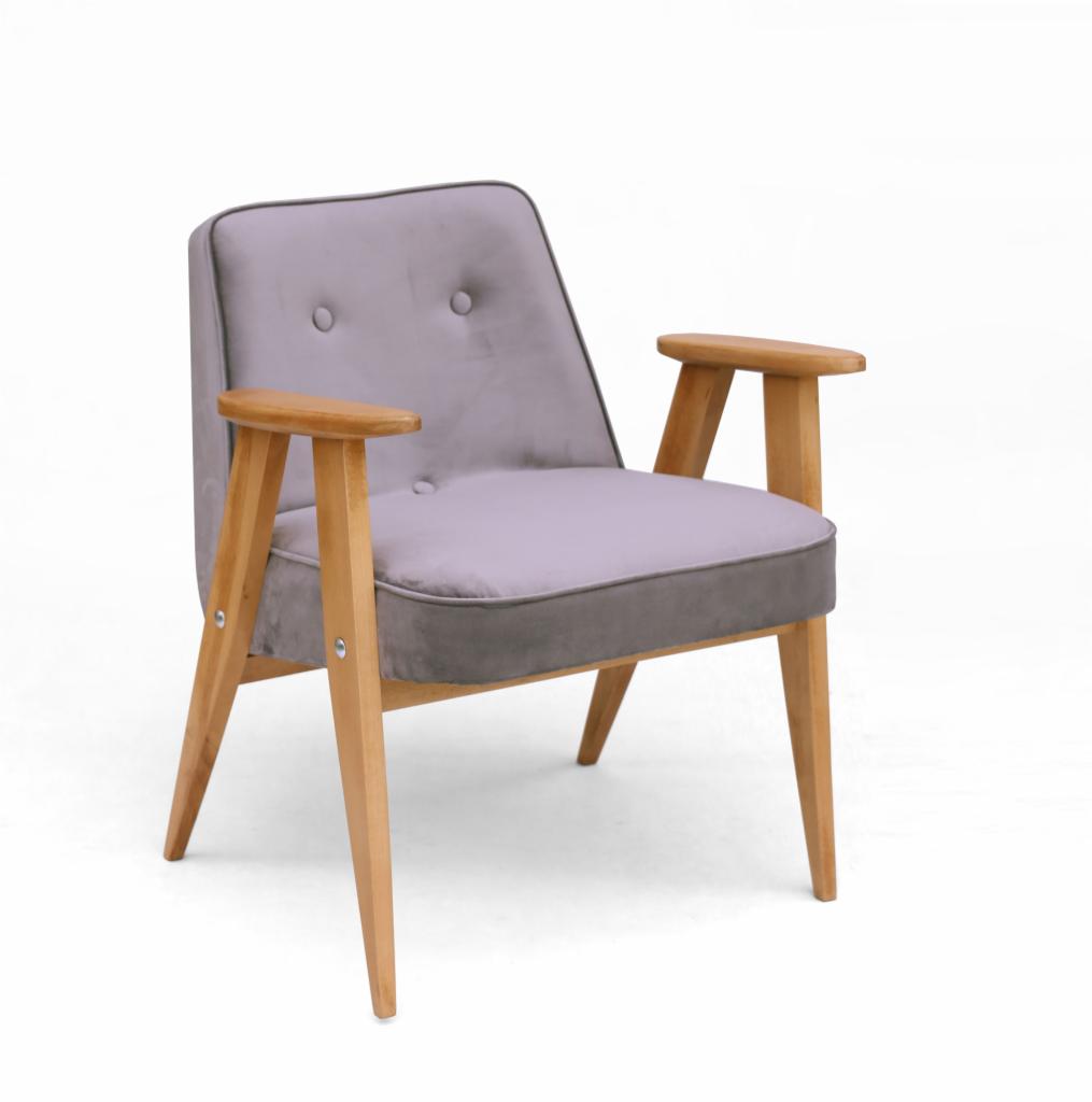 Fotel tapicerowany w stylu retro, z jasnofioletową tkaniną i drewnianymi podłokietnikami, na białym tle.
