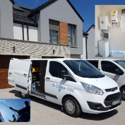 Dwa białe busy firmy Clima-VAC zaparkowane przed nowoczesnym domem z zainstalowanym systemem magazynowania energii widocznym w prawym górnym rogu, otwarte drzwi jednego z busów ukazują narzędzia...