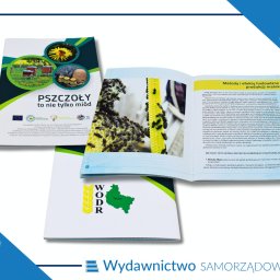 WYDAWNICTWO SAMORZĄDOWE spółka z o.o. - Otwarta broszura informacyjna z tekstem 'PSZCZOŁY to nie tylko miód' oraz zdjęciem uli z pszczołami na plastrach miodu, leżąca na innych broszurach z logo WODR i napisem 'Wydawnictwo SAMORZĄDOWE'.