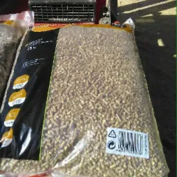 Worek 15 kg z pelletem drzewnym, widoczny kod kreskowy i informacje o kaloryczności, na czerwonym podłożu.