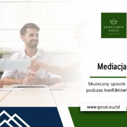 Uśmiechnięty mężczyzna w białej koszuli siedzi przy stole, podaje dłoń osobie po drugiej stronie, symbolizując zawarcie porozumienia podczas mediacji. W tle logo kancelarii prawnej i hasło...