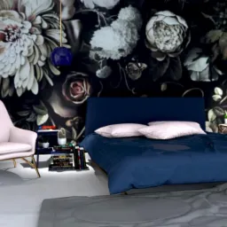 Wizualizacja sypialni z ciemną tapetą w kwiaty, granatowym łóżkiem i pudrowo-różowym fotelem na złotych nóżkach, oświetlona lampami wiszącymi z granatowymi kloszami.