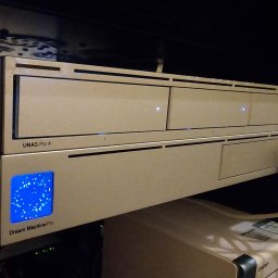 Proste IT Sp. z o.o. - Serwer NAS UNAS Pro 4 i Dream Machine Pro w szafie rack, z podłączonymi kablami sieciowymi. Widoczne diody sygnalizujące pracę urządzeń.