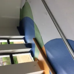 Fragment układania podłogi z kolorowej, wzorzystej nawierzchni w pomieszczeniu z oknem; widoczny rozwinięty rulon materiału.