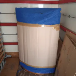 Zabezpieczony mebel w niebieskim pokrowcu i kartonach w przestrzeni ładunkowej, gotowy do transportu w Zamościu.