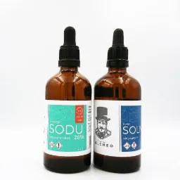 Dwie brązowe butelki z zakraplaczami na białym tle, jedna z etykietą 'chloryn sodu, aktywator MMS 28%', druga z etykietą 'kwas solny, aktywator H' i logo firmy Alcheo z wizerunkiem mężczyzny...