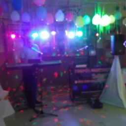 Scena z instrumentami, nagłośnieniem i kolorowymi światłami, przygotowana na imprezę z dekoracjami balonowymi.