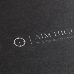 Logo firmy na ciemnoszarym papierze z napisem 'AIM HIGH' i mottem 'work smarter not harder' oraz symbolem celownika.