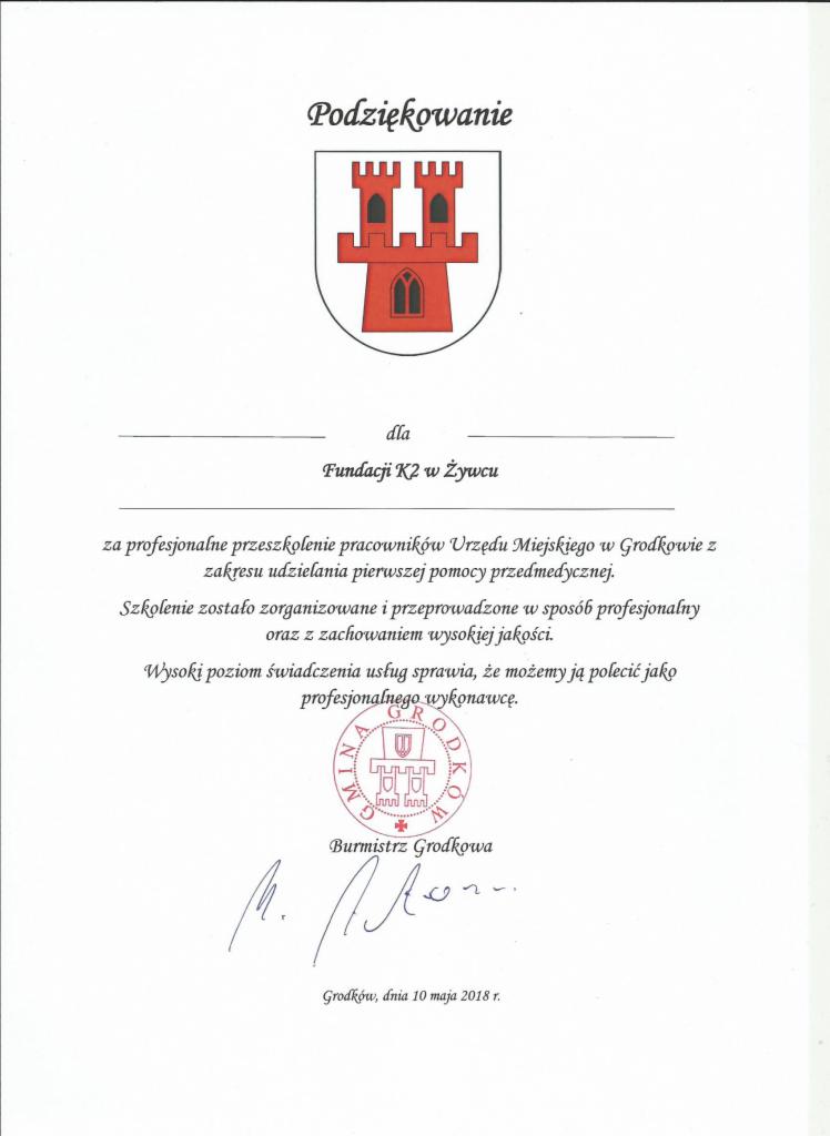 Skan dokumentu z podziękowaniem dla Fundacji K2 w Żywcu za profesjonalne przeszkolenie pracowników Urzędu Miejskiego w Grodkowie z zakresu udzielania pierwszej pomocy przedmedycznej, z herbem...