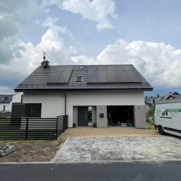 Greenhouse-RS Sp. z o.o. - Nowoczesny dom jednorodzinny z panelami słonecznymi na dachu, zaparkowany biały bus firmy instalacyjnej z widocznym logo i hasłem reklamowym.