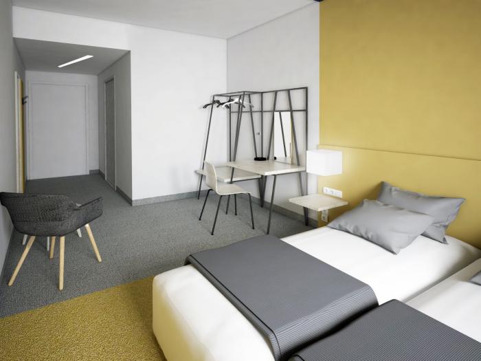 Pokój hotelowy z dwoma łóżkami, biurkiem i krzesłem w nowoczesnym stylu, z żółtą ścianą i szarymi akcentami.