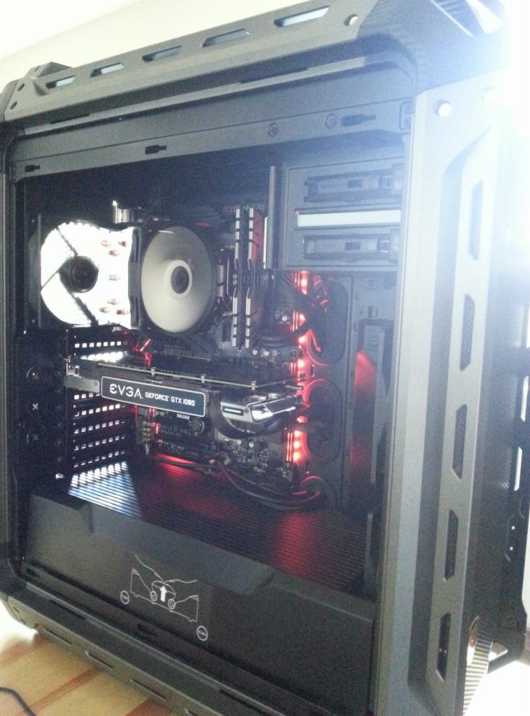 Wnętrze obudowy komputera stacjonarnego z widoczną kartą graficzną EVGA GeForce GTX 1080, chłodzeniem procesora i czerwonym podświetleniem LED.