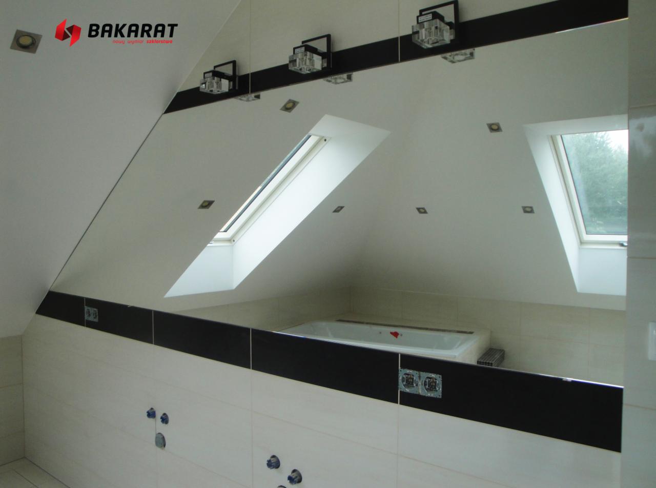 Lustro na wymiar w łazience na poddaszu, odbijające okno dachowe i wannę, z widocznym logo firmy Baccarat w górnym rogu.