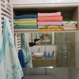 MM-Design - Półka z ręcznikami w łazience, widoczna w lustrzanym odbiciu podczas robienia zdjęcia.