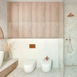 Nowoczesna łazienka z drewnianymi szafkami, białymi sanitariatami i miedzianymi akcentami, w tym deszczownica i bateria bidetowa.